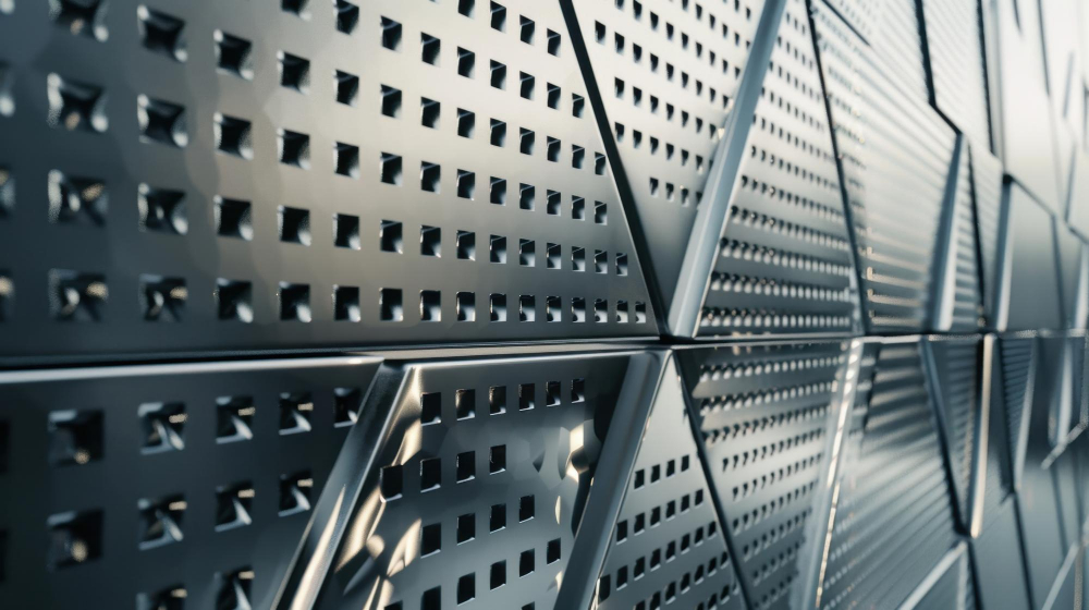 Metalowa fasada hali stalowej z perforowanymi panelami, symbolizująca nowoczesne technologie w budowie obiektów przemysłowych.
